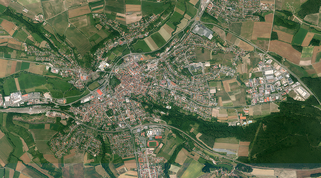 Das Farbluftbild zeigt, Neustadt a.d.Aisch. Zu sehen sind Felder, Wiesen, Gewässer, Straßen und Gebäude.